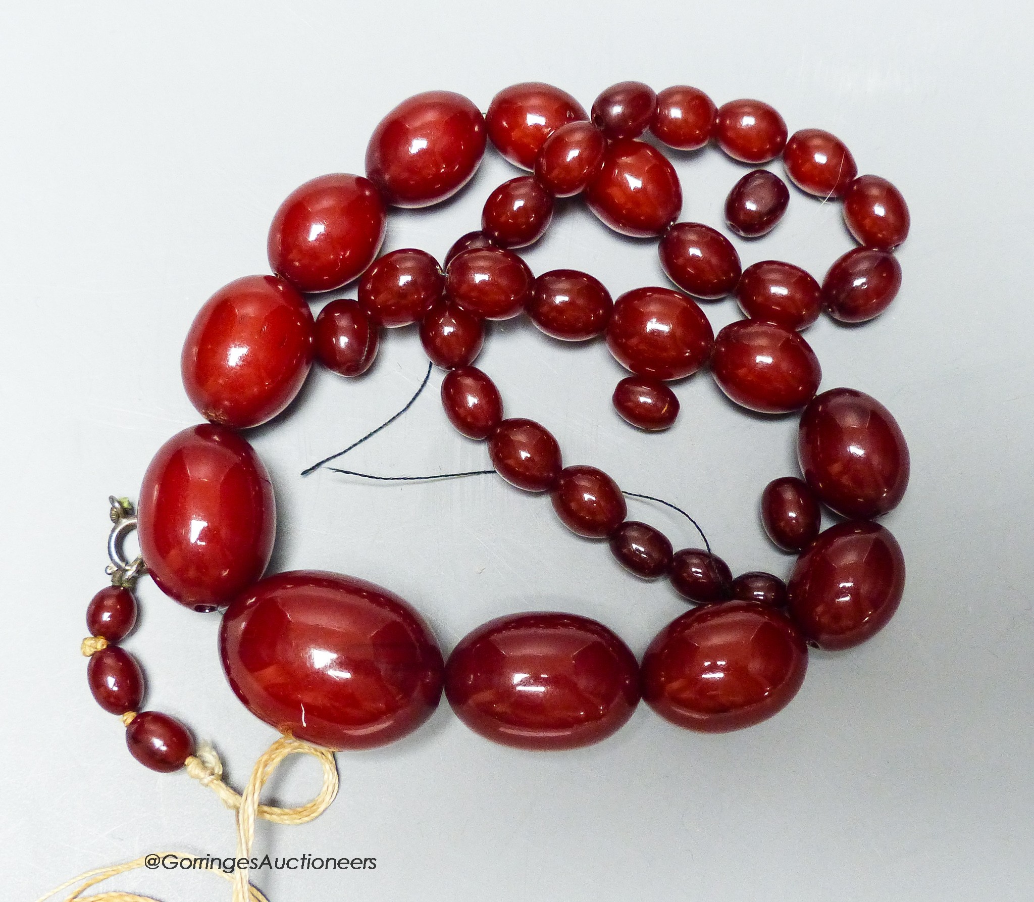 A single strand graduated simulated cherry amber necklace (a.f.) gross 56 grams.